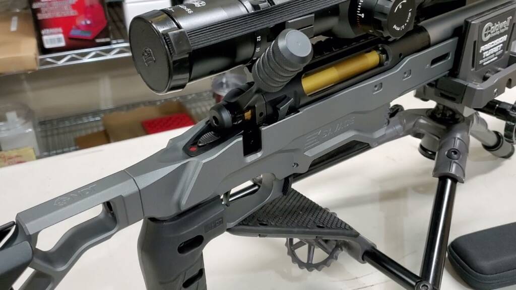 Close-up of a rifle chassis and trigger area on a bench
